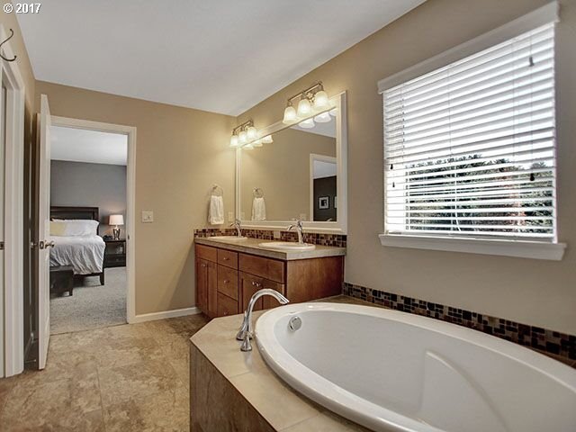 9478 Northwest Ember Lane Portland, OR 97229 - Photo 12 of 23 a bathroom with a tub a sink and a mirror