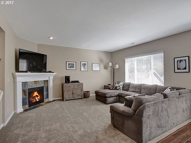 9478 Northwest Ember Lane Portland, OR 97229 - Photo 2 of 23 a living room with furniture a flat screen tv and a fireplace