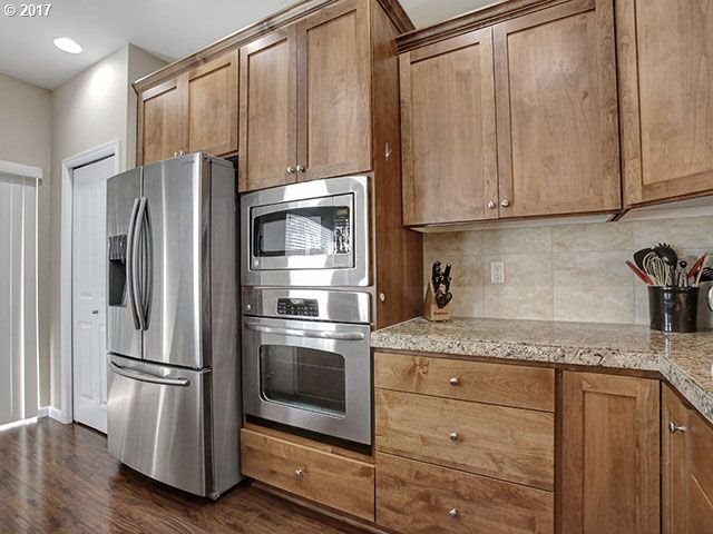 9478 Northwest Ember Lane Portland, OR 97229 - Photo 7 of 23 a kitchen with granite countertop stainless steel appliances a refrigerator and a sink