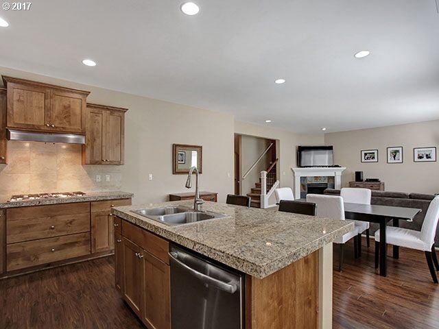 9478 Northwest Ember Lane Portland, OR 97229 - Photo 8 of 23 a kitchen with granite countertop stainless steel appliances sink stove dining table and chairs