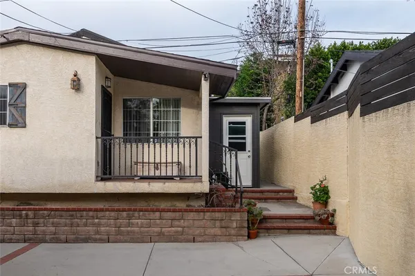 a view of a house with a small yard and wooden floor and fence
