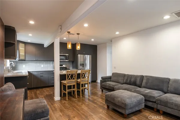 a living room with stainless steel appliances kitchen island granite countertop furniture and a large window