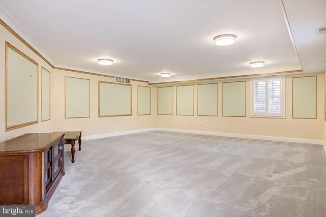 a view of an empty room with windows & cabinet