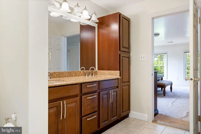 a bathroom with a granite countertop sink a toilet a mirror and shower