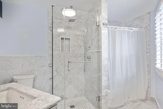 a bathroom with a sink toilet vanity and shower