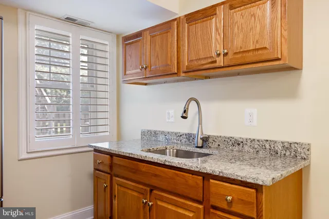 a bathroom with a granite countertop toilet sink and mirror