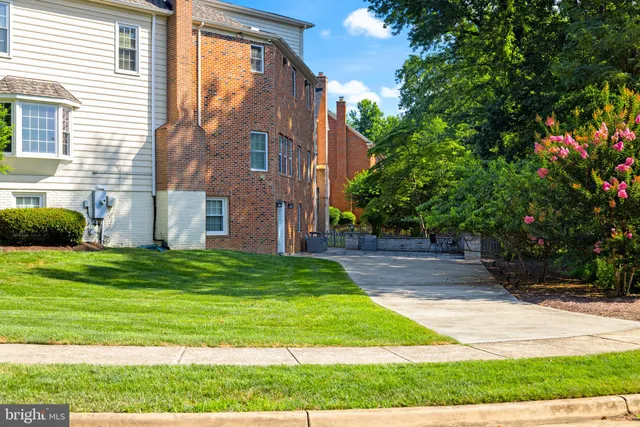 a view of a house with backyard and trees
