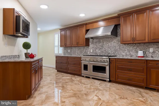 a kitchen with stainless steel appliances granite countertop a stove sink and cabinets