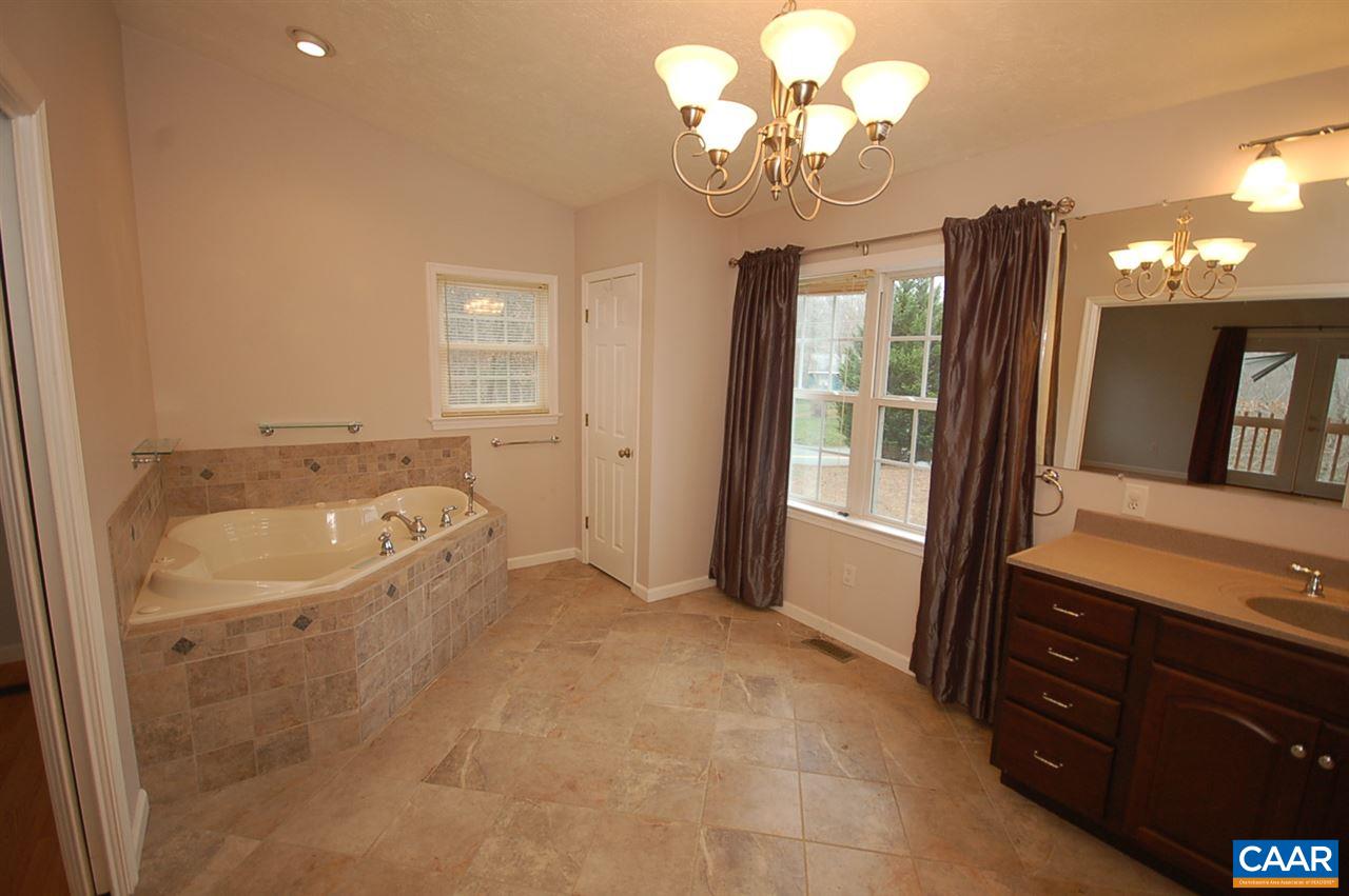 5075 Celt Road Stanardsville, VA 22973 - Photo 32 of 36 a view of a bathroom with a tub sink and a mirror