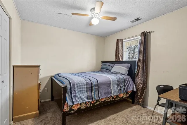 a bedroom with a bed and a chandelier fan