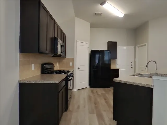 a kitchen with a sink stove and refrigerator