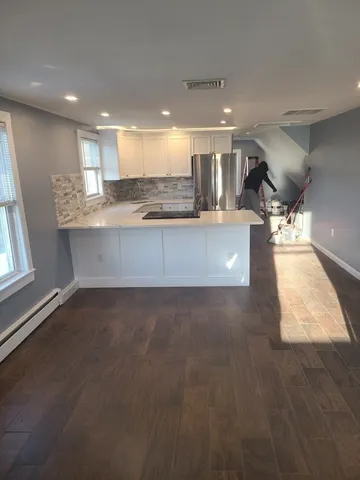 a large kitchen with stainless steel appliances a large counter top
