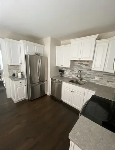 a kitchen with a refrigerator sink and cabinets