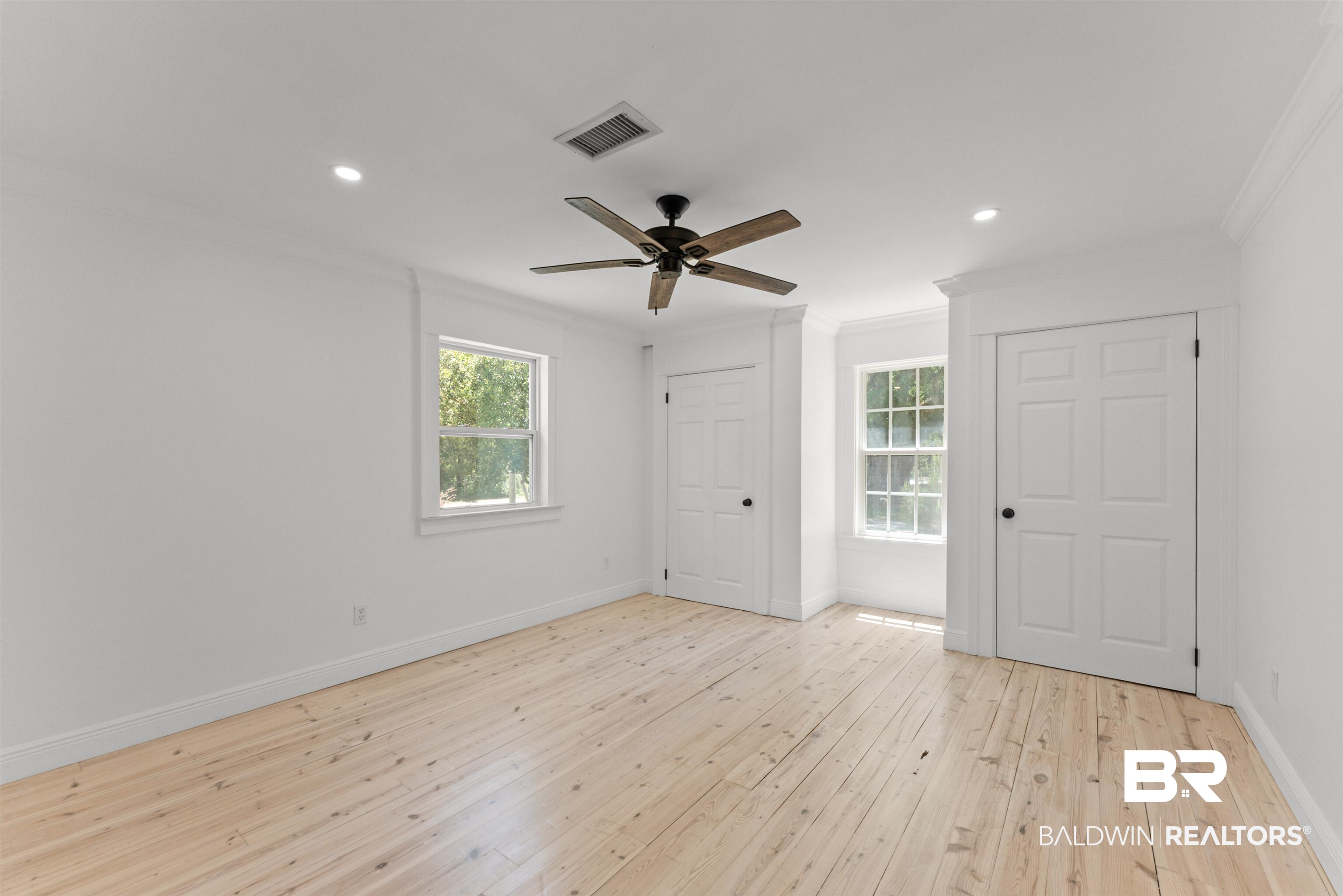 6447 Bemis Lane Bon Secour, AL 36511 - Photo 49 of 62 Bright interior space featuring light wood-finish flooring, white walls, and a ceiling fan with dark wood-tone blades
