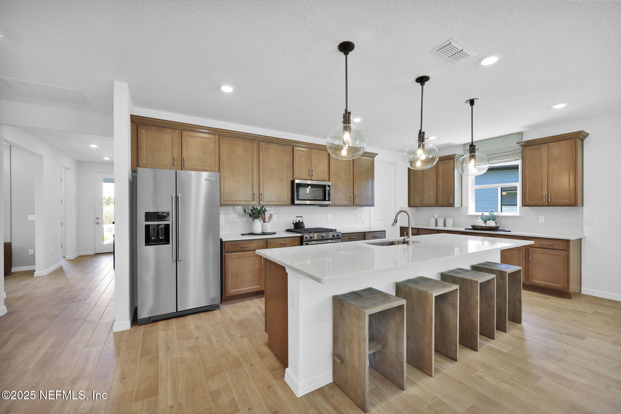 124 Headstream Drive St. Johns, FL 32259 - Photo 4 of 22 a kitchen with stainless steel appliances granite countertop a sink a stove a refrigerator and island with wooden floor