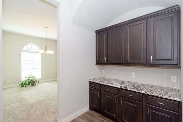 a kitchen with kitchen island granite countertop stainless steel appliances lots of counter space a sink and a refrigerator