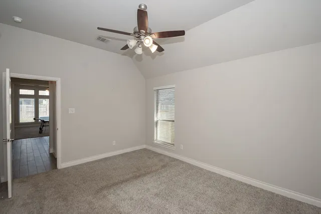 an empty room with wooden floor mirror and windows