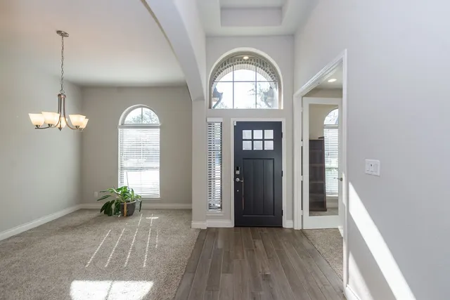 a view of empty room with wooden floor and windows