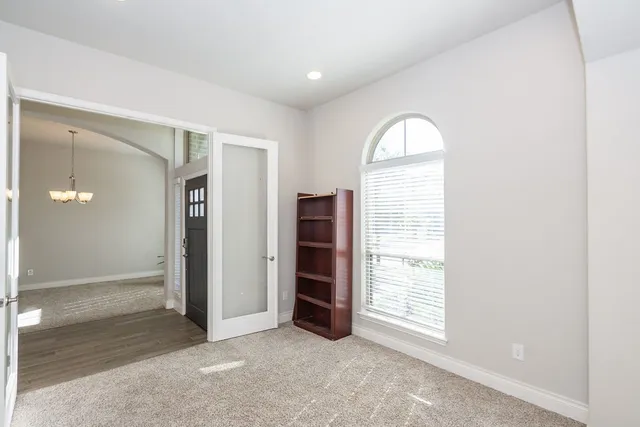 a view of a hallway with wooden floor and chandelier