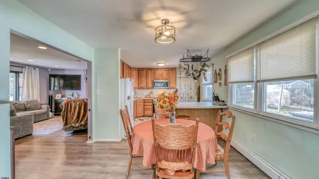 a dining room with furniture a chandelier and wooden floor