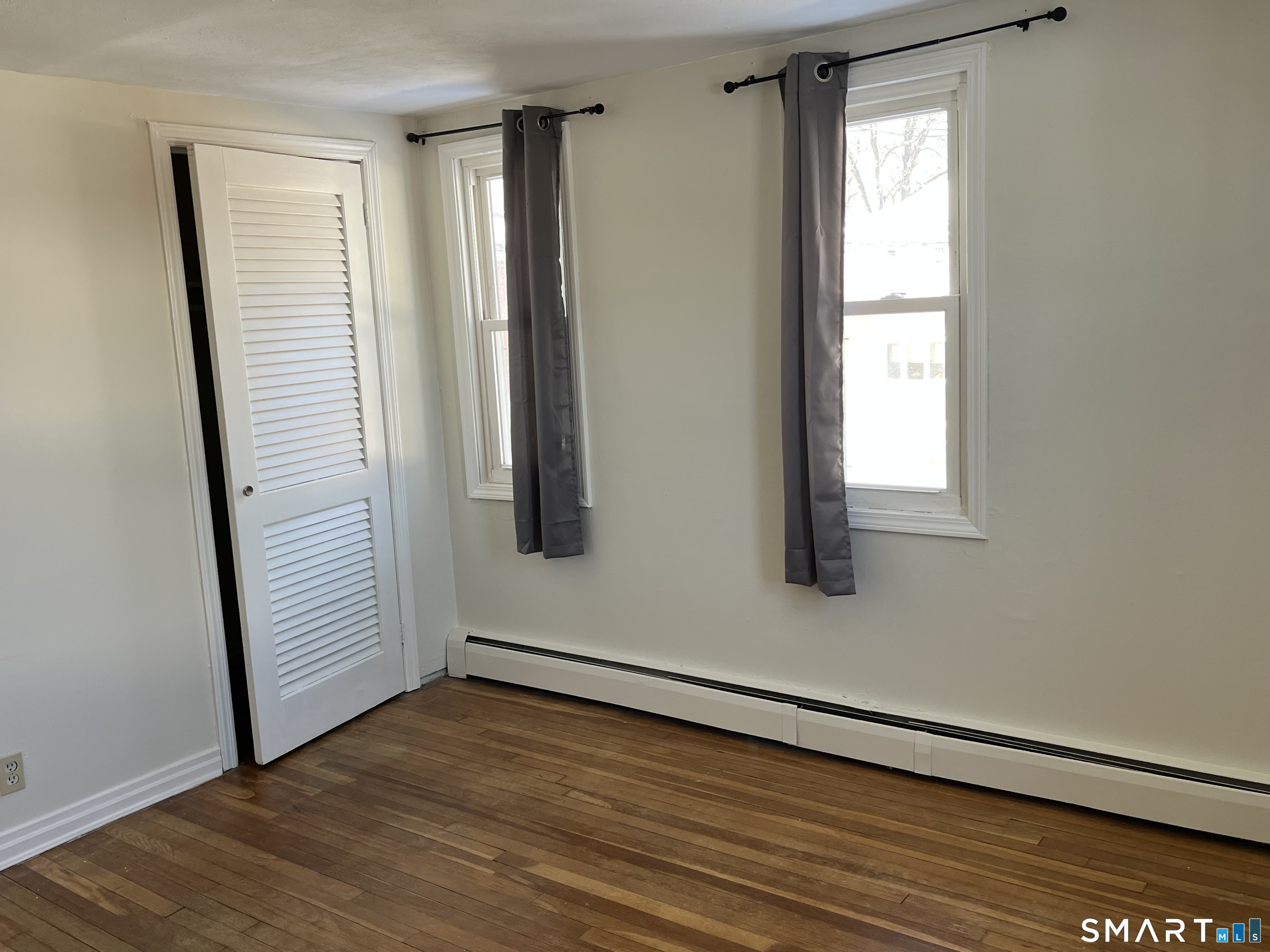 20 John Street Southington, CT 06489 - Photo 11 of 17 an empty room with wooden floor and windows