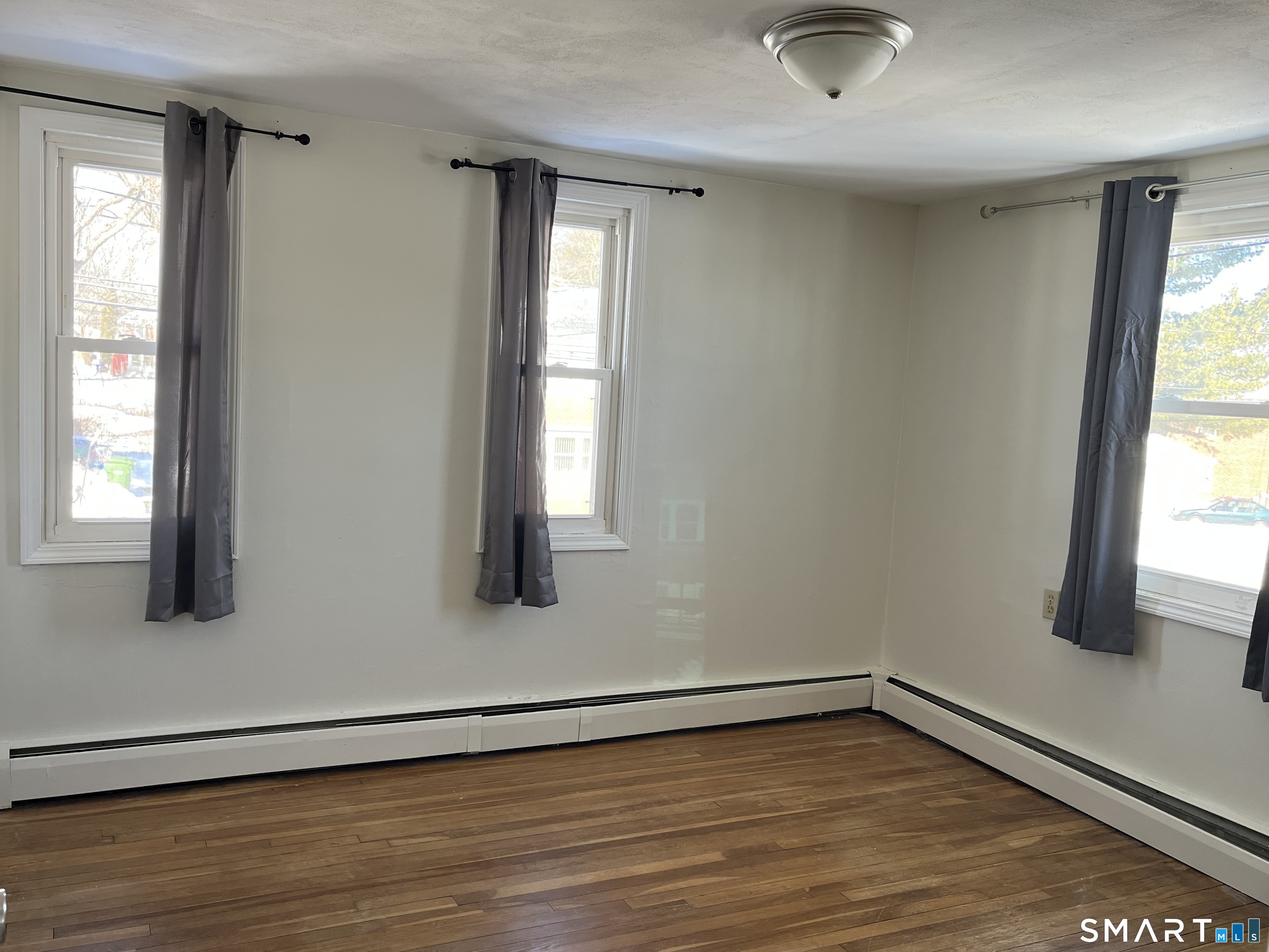 20 John Street Southington, CT 06489 - Photo 10 of 17 an empty room with wooden floor and windows
