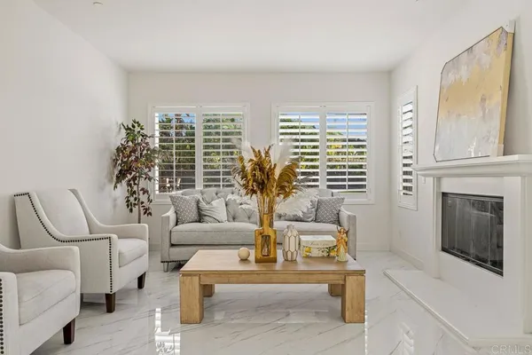 a living room with furniture and three large window