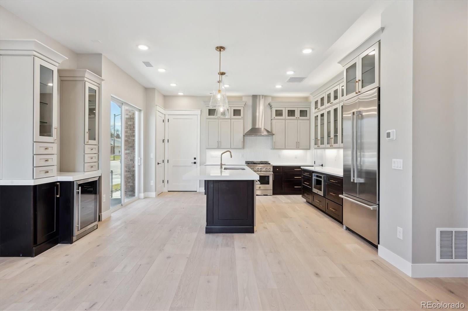 396 East Orchard Road Centennial, CO 80121 - Photo 4 of 34 a large kitchen with stainless steel appliances granite countertop a refrigerator a sink dishwasher a stove and a refrigerator with wooden floor