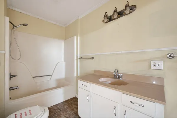 a view of an empty room with wooden floor fireplace and a window