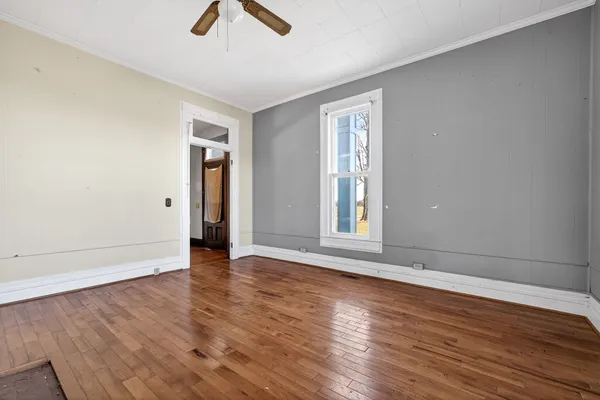 a view of empty room with wooden floor and fireplace