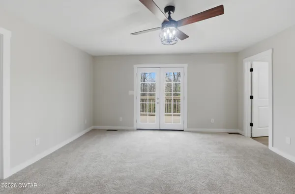 a view of a big room with a chandelier fan and bathroom