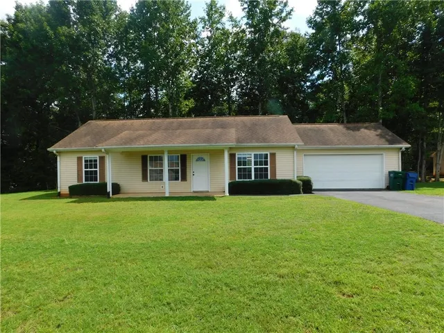 a front view of a house with a garden