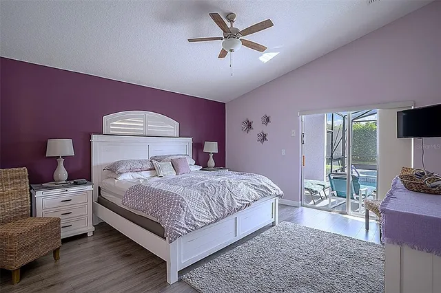 a bedroom with a bed a chandelier and dresser