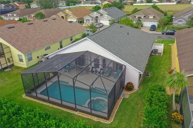 an aerial view of a house with a yard and large tree