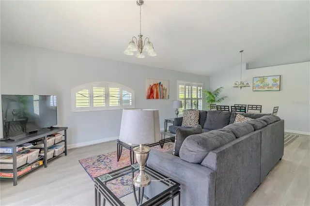 a living room with furniture a dining table and a flat screen tv