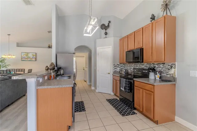 a kitchen with kitchen island granite countertop a sink cabinets and stainless steel appliances