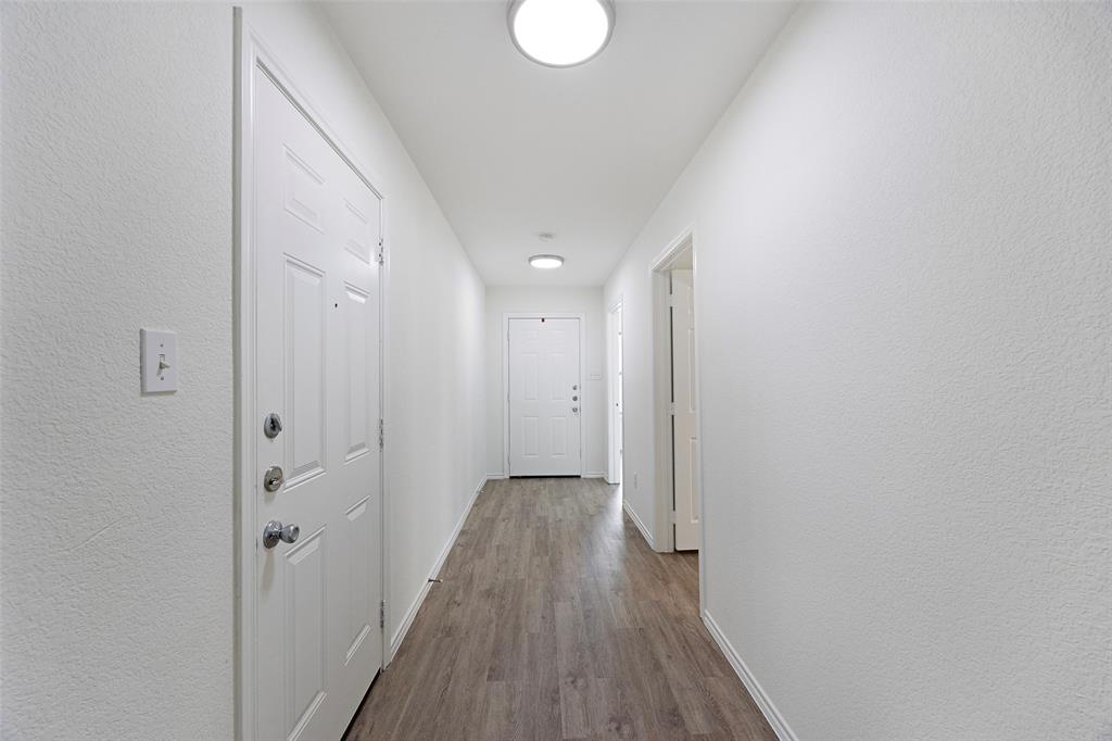 1605 Village Park Trail Burleson, TX 76028 - Photo 4 of 29 Hall with a textured wall and dark wood-style flooring