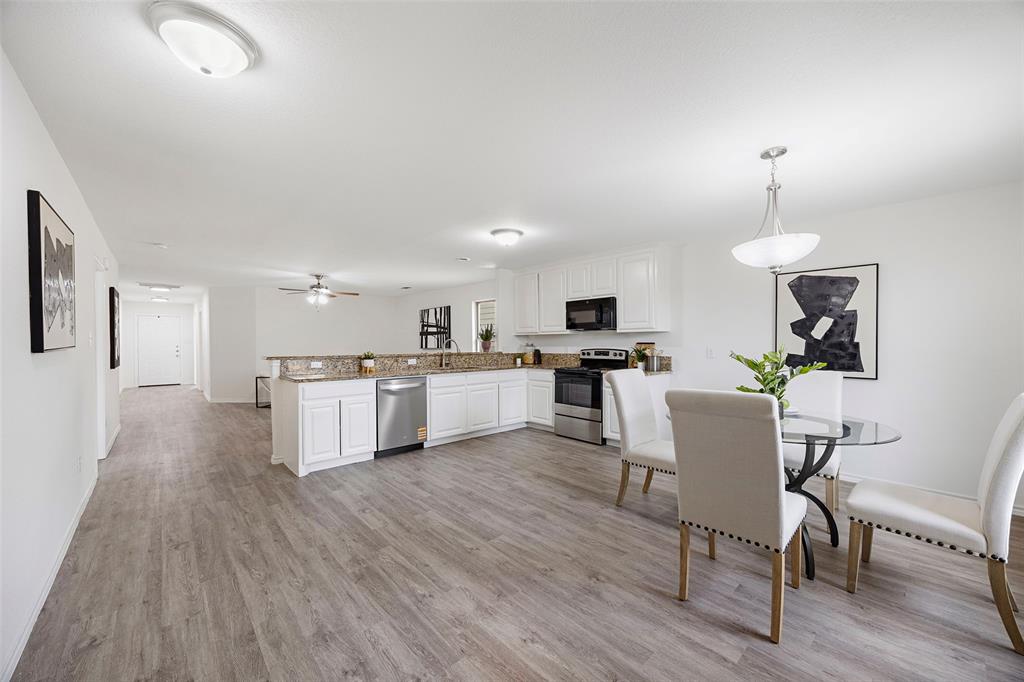 1605 Village Park Trail Burleson, TX 76028 - Photo 9 of 29 Kitchen featuring a peninsula, white cabinetry, light wood finished floors, stainless steel appliances, and decorative light fixtures