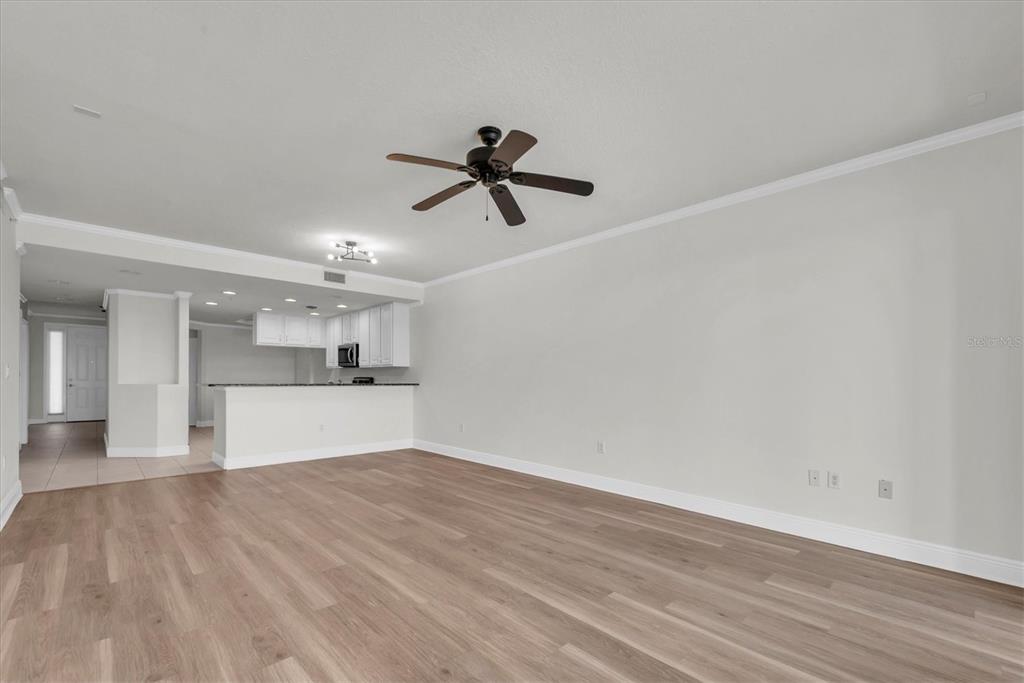 7069 Key Haven Road, Unit 302 Seminole, FL 33777 - Photo 16 of 65 a view of kitchen and empty room with wooden floor
