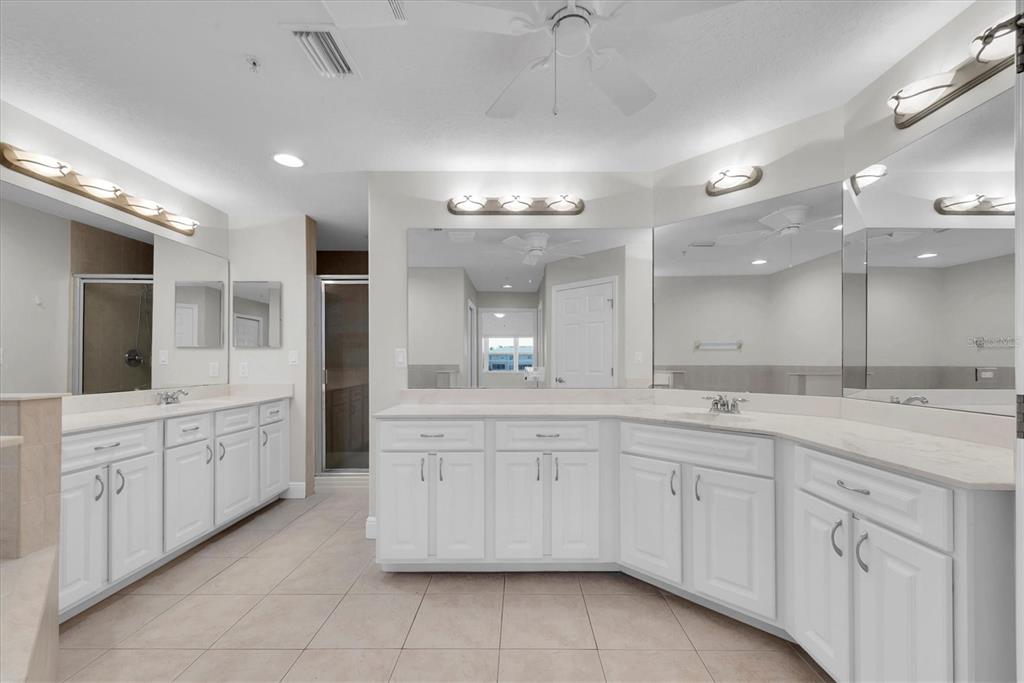 7069 Key Haven Road, Unit 302 Seminole, FL 33777 - Photo 25 of 65 a large bathroom with a large mirror vanity and a sink