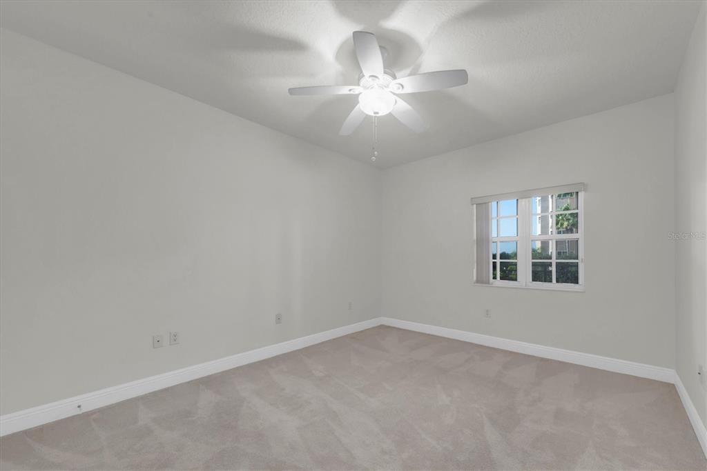 7069 Key Haven Road, Unit 302 Seminole, FL 33777 - Photo 28 of 65 an empty room with a chandelier fan and windows