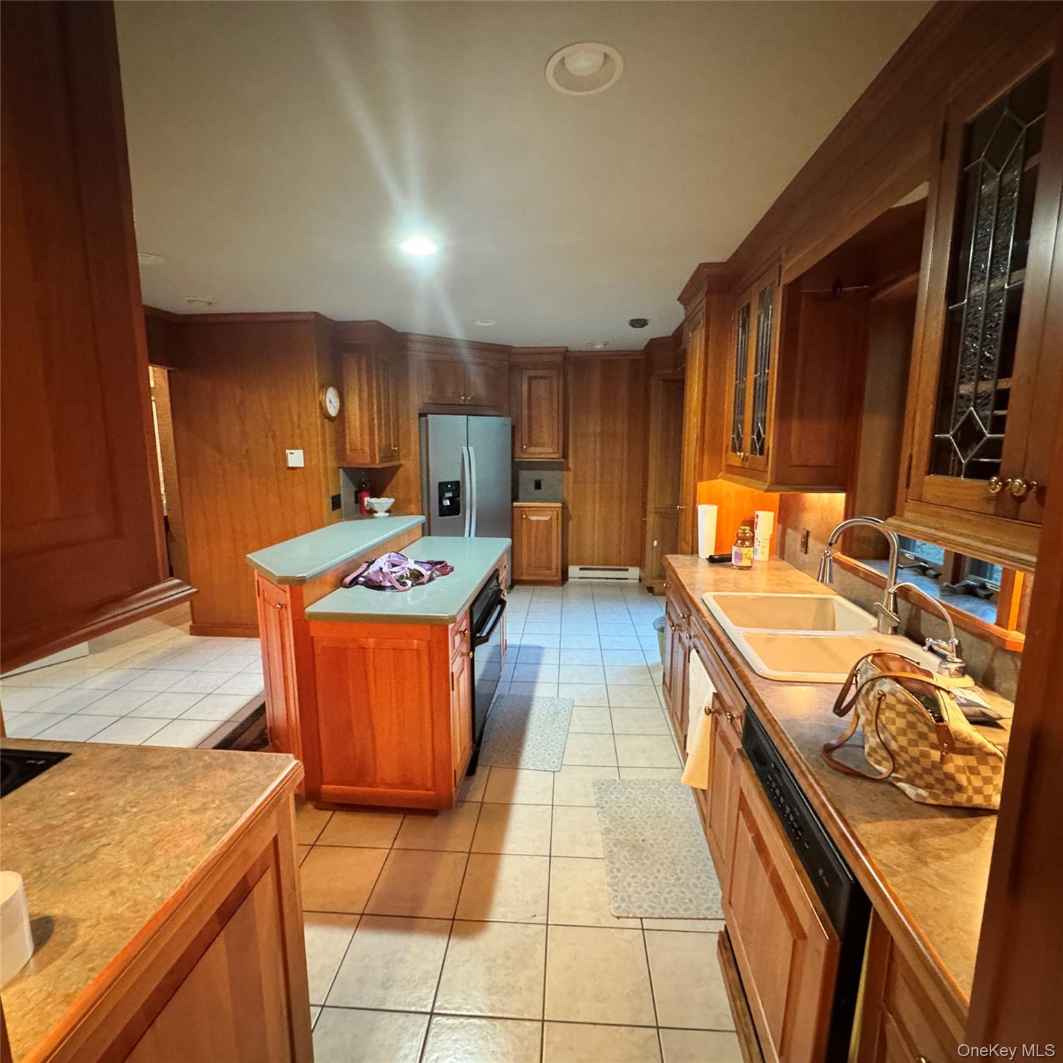 67 Steele Road New Windsor, NY 12553 - Photo 22 of 34 Wood cabinetry with leaded glass accents, dual basin sink, stainless steel refrigerator, and a kitchen island with built-in appliances