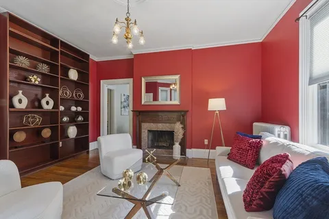 a living room with furniture a fireplace and a chandelier