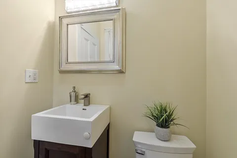 a white sink sitting under a bathroom mirror
