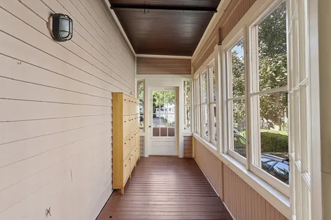 a view of a hallway with wooden floor and staircase
