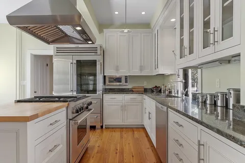 a kitchen with stainless steel appliances granite countertop a stove and cabinets