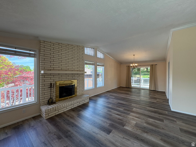 595 Meadowlark Road Orem, UT 84097 - Photo 2 of 87 Spacious living area featuring plank wood-finish flooring and a brick-faced fireplace with a brass-trimmed insert