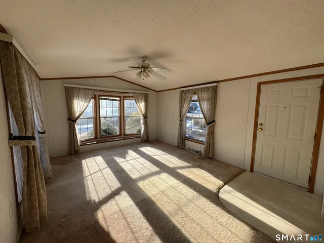 a view of entryway with an empty room and wooden floor