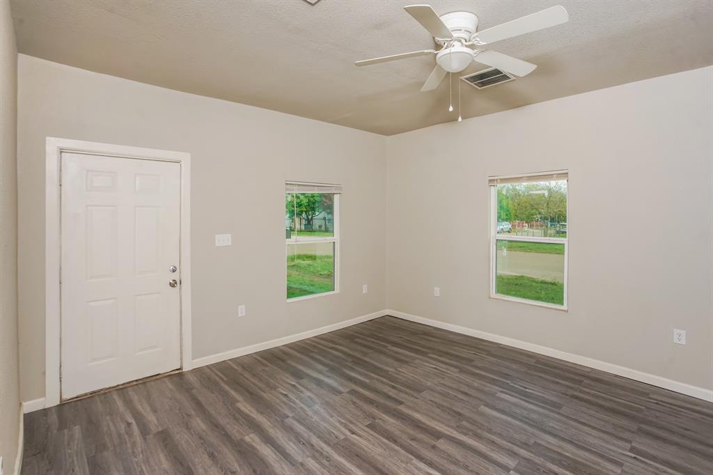 2402 Summer Avenue Waco, TX 76708 - Photo 10 of 15 Interior room featuring wood-finish flooring, two windows, and a ceiling fan