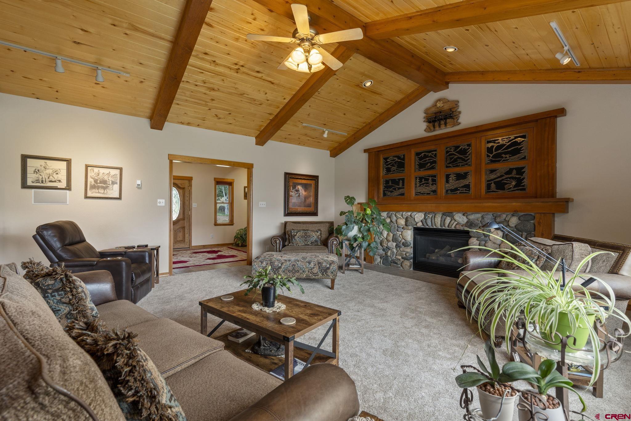 33140 Highway 550 Durango, CO 81301 - Photo 16 of 38 a living room with furniture a fireplace and a dining table with wooden floor